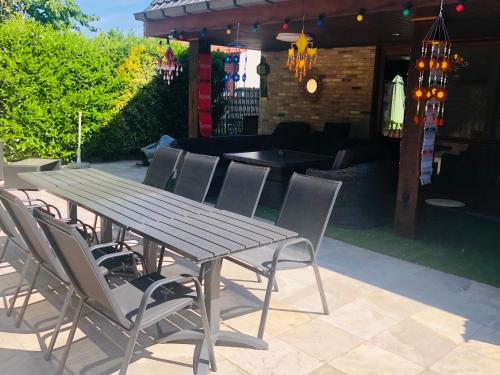 a wooden table and chairs on a patio at B&B Kookhai in Kluisbergen