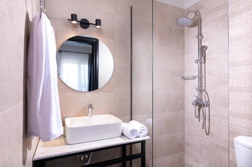 a bathroom with a sink and a mirror at ELLE Rooms & Suites in Paralia Katerinis