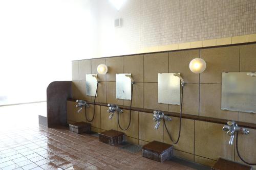 a bathroom with a row of urinals on a wall at Tateshina Park Hotel in Chino