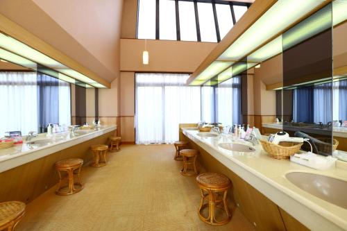 Baño grande con 2 lavabos y taburetes en Tateshina Park Hotel en Chino