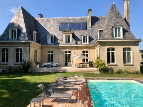 une grande maison avec une piscine devant dans l'établissement Le Château d'Hermonville B&B / Chambres d'hôtes, à Hermonville