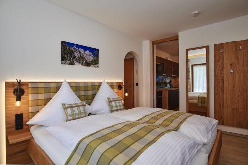 a bedroom with a large white bed with pillows at Ferienwohnungen Bergfex in Ramsau