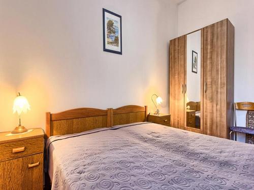 1 dormitorio con 1 cama grande y espejo en Apartment Lucija, en Kaštela