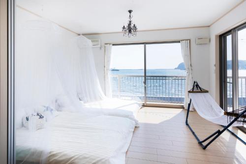 um quarto com uma rede de descanso e vista para o oceano em Marine House KAKISAKI em Shimoda