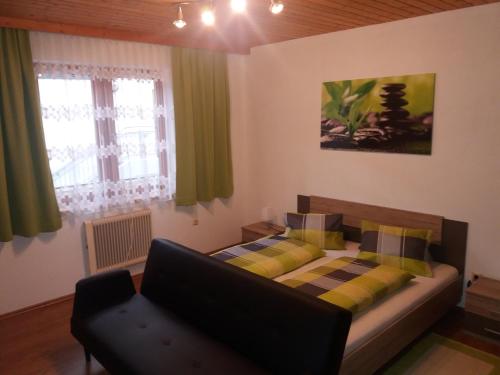 um quarto com uma cama, um sofá e janelas em Ferienwohnung Alex em Heiligenblut