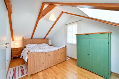 a bedroom with a bed and a green cabinet at Holiday Home Fančita in Tuheljske Toplice
