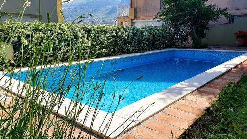 a swimming pool in a yard with a hedge at Villa AYA - with sauna and outdoor swimming pool in Mostar