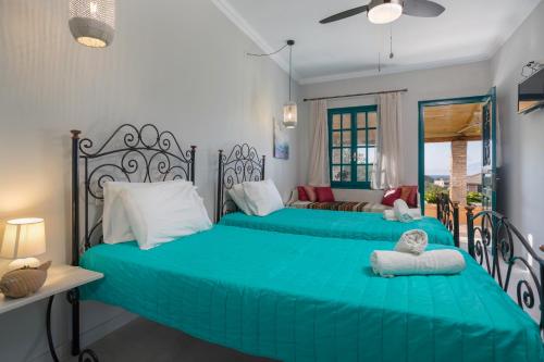 two beds in a bedroom with green sheets and pillows at LITHARI PENTHOUSE in Alikanas