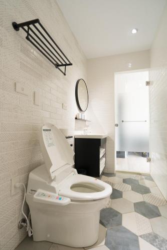 a bathroom with a toilet and a sink and a mirror at The Way Inn in Taichung