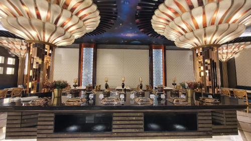 a restaurant with a long table and large chandeliers at Hotel Sepal in Bathinda