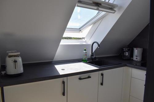 cocina con fregadero y ventana en Wohnung Wattwurm en Norderney