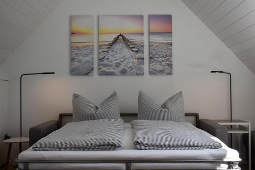 ein Schlafzimmer mit einem Bett und zwei Gemälden an der Wand in der Unterkunft Wohnung Wattwurm in Norderney