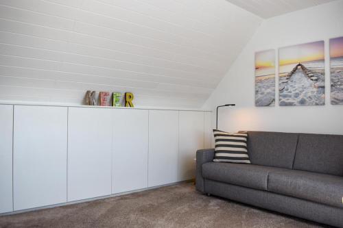 sala de estar con sofá y armarios blancos en Wohnung Wattwurm en Norderney