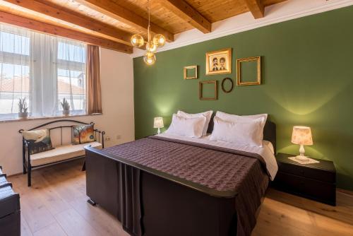a bedroom with a large bed with a green wall at Main Square Duplex with Rooftop Terrace in Split