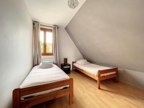 una camera con due letti e una finestra di Gite du vignoble a Riquewihr