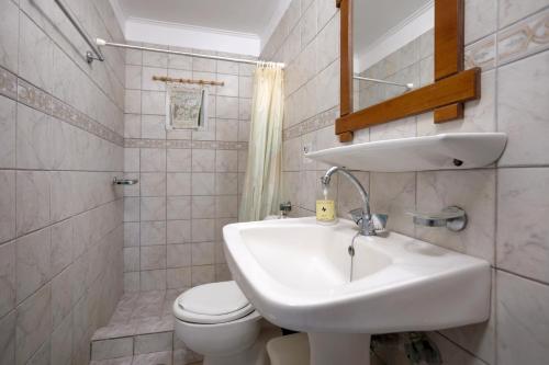 a white bathroom with a sink and a toilet at LITHARI PENTHOUSE in Alikanas