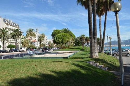 un parc avec des palmiers et un éclairage de rue dans l'établissement Parc Ferber - Charmant studio rénové, rez-de-jardin, proche mer, Carras, à Nice