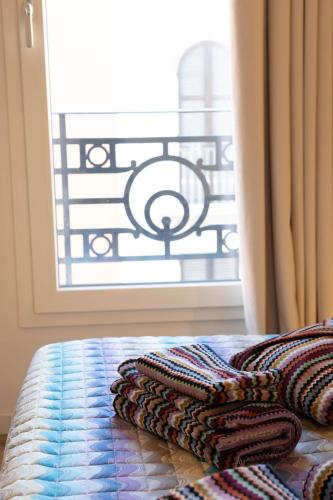 a group of towels sitting on a bed in front of a window at Vespasiani Suites in San Benedetto del Tronto