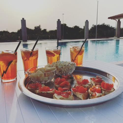 a plate of food on a table next to a pool at Verde Oliva Residence in Ispica