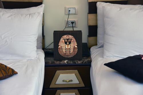 a bed room with two beds and a box on a table at Giza Pyramids View Inn in Cairo