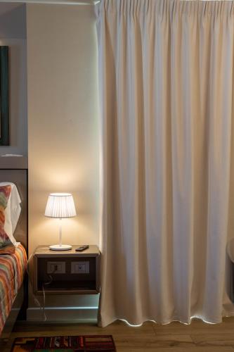 a bedroom with a white curtain next to a bed at Vespasiani Suites in San Benedetto del Tronto