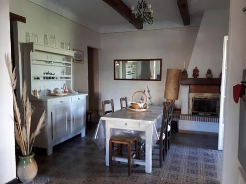 une cuisine avec une table et des chaises ainsi qu'une cheminée dans l'établissement MAISON 6 personnes 80M2 ENTRE LES CALANQUES DU MUGEL ET FIGUEROLLES, à La Ciotat