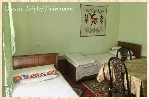 a room with two beds and two chairs in it at Spring Family Guest House in Tersak