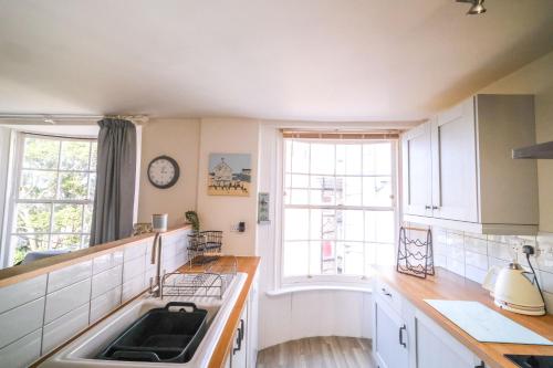 een keuken met een wastafel en een groot raam bij Elizabeth: Charming two bedroom apartment in centre of town in Ramsgate