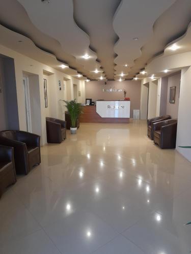 a large lobby with chairs and a reception desk at Hotel Caras in Oraviţa