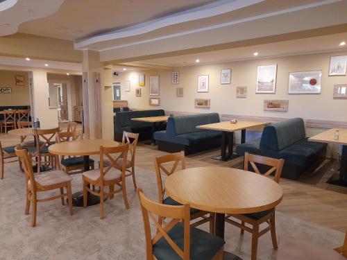 a waiting room with tables and couches at Hotel Caras in Oraviţa