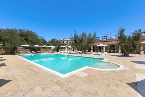 a swimming pool with a pool table and chairs at Masseria San Biagio by BarbarHouse in Calimera