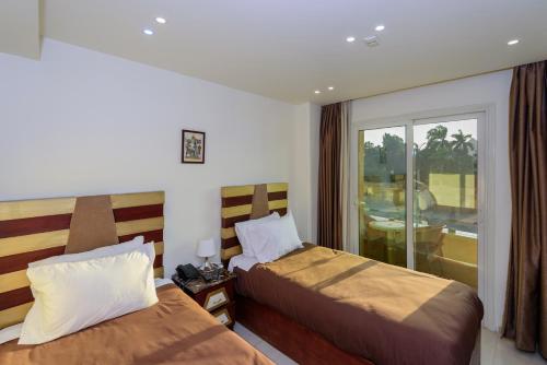 a hotel room with two beds and a balcony at Giza Pyramids View Inn in Cairo