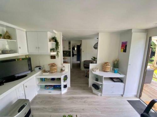 a living room with white cabinets and a flat screen tv at Accommodatie in Eeserheide in De Pol