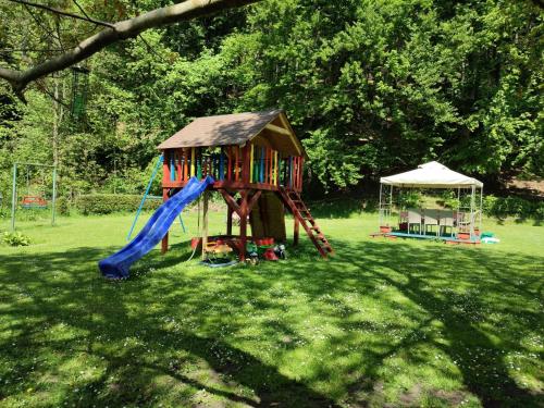 a playground with a slide and a gazebo at Apartmany Chribska in Chřibská