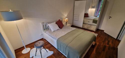 a small bedroom with a bed and a lamp at Senevita Wangenmatt in Bern