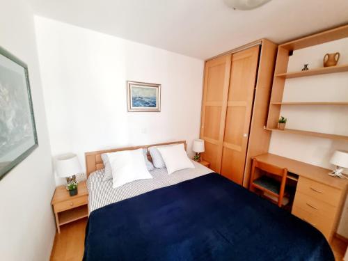 a bedroom with a blue bed and wooden cabinets at Sea view App Mirta in Umag
