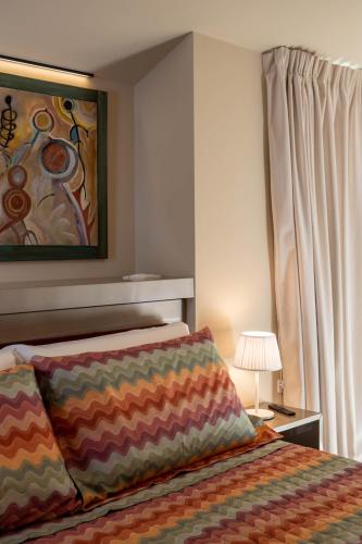 a bedroom with a bed and a painting on the wall at Vespasiani Suites in San Benedetto del Tronto