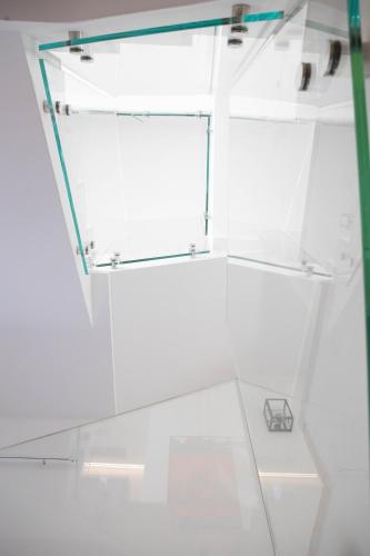 a glass walk in shower with a glass shelf at Vespasiani Suites in San Benedetto del Tronto