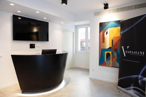 a lobby with a black counter and a painting on the wall at Vespasiani Suites in San Benedetto del Tronto