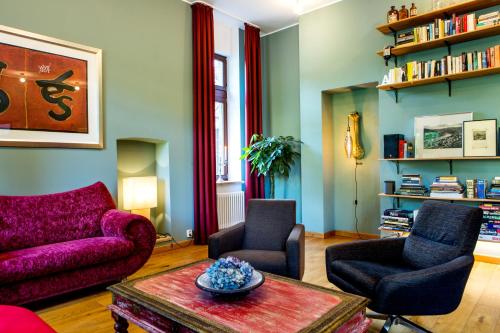 a living room with a purple couch and two chairs at Hotel Villa Vinum Cochem in Cochem
