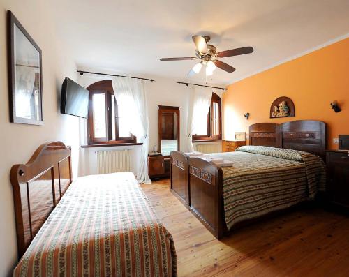 1 dormitorio con 2 camas y ventilador de techo en Aurora B&B, en Cividale del Friuli