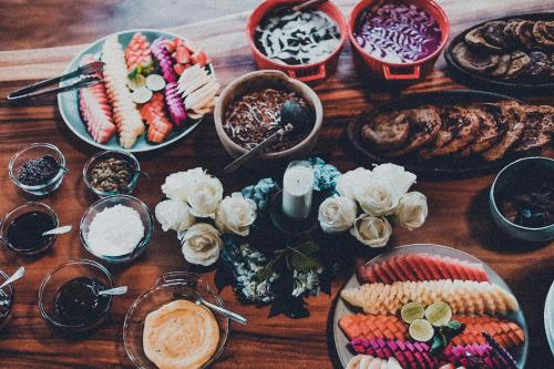 a wooden table topped with plates of food and other foods at Desa Eko in Munduk