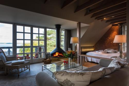 een woonkamer met een bank, een bed en een open haard bij Fleesensee Resort & Spa in Göhren-Lebbin