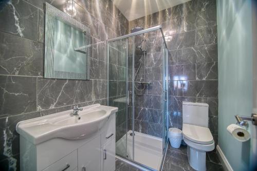a bathroom with a sink and a shower and a toilet at Royal Harbour Retreat - Balcony, sea view property in Ramsgate