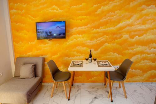 a dining room with a table and a yellow wall at RENT HOUSE ANEMOS in Iraklitsa