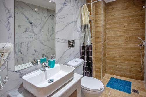 a bathroom with a sink and a toilet and a shower at RENT HOUSE ANEMOS in Iraklitsa