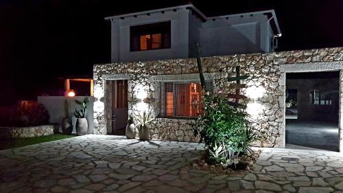 a stone house at night with a driveway at Luxury Villa Athina in Nikiana