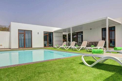a villa with a swimming pool and lounge chairs at Villa Ponzos Chalet independiente y privado in Triquivijate