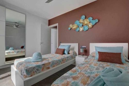 a bedroom with two beds and a clock on the wall at Villa Ponzos Chalet independiente y privado in Triquivijate