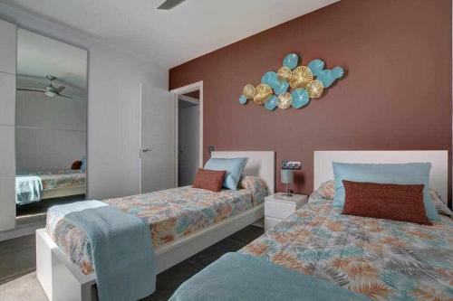 a bedroom with two beds and a clock on the wall at Villa Ponzos Chalet independiente y privado in Triquivijate